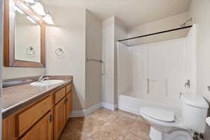 Bathroom featuring vanity, shower / bath combination, and light tile patterned floors