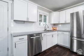 Kitchen featuring stainless steel appliances, white cabinetry, and dark wood finished floors