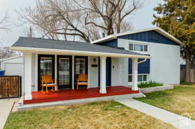 View of front of home with a porch, an outdoor structure, board and batten siding, and a garage