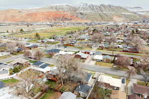 Aerial view of property and surrounding area featuring nearby suburban area and a mountain backdrop