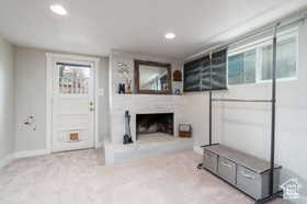 Unfurnished living room with a fireplace with raised hearth, carpet floors, and recessed lighting
