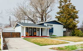 Tri-level home featuring a porch, concrete driveway, a carport, and stucco siding