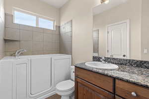 Full bathroom featuring a garden tub and vanity