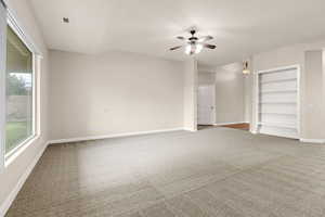 Empty room featuring light carpet and a ceiling fan