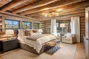 Bedroom with a wood ceiling with exposed beams, multiple windows, light wood-style flooring, and a chandelier