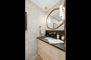 Bathroom with vanity and a textured wall