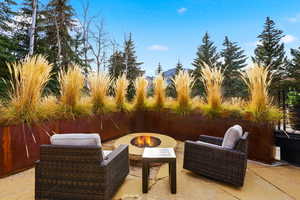 Fenced backyard featuring a patio and an outdoor living space with a fire pit