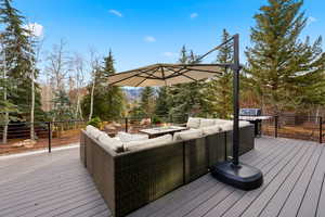 Wooden deck with an outdoor living space and a grill