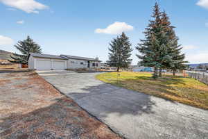 View of front of home with concrete driveway, a garage, and a metal roof