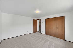 Unfurnished bedroom with a closet, carpet floors, and a textured ceiling