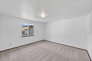 Spare room featuring a textured ceiling and carpet flooring