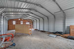 Misc room with metal wall, a garage, and vaulted ceiling