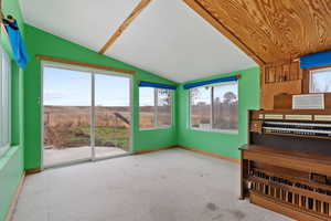 Unfurnished sunroom featuring vaulted ceiling