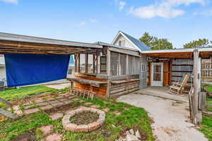 Rear view of property featuring a sunroom and a patio area