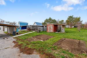 View of grassy yard featuring a storage shed and a wooden deck