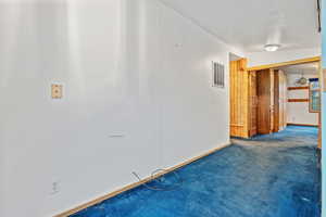 Spare room featuring carpet and baseboards