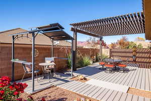 Deck with outdoor dining space, a fenced backyard, and a pergola