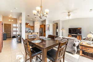 Dining space featuring a chandelier, light tile patterned floors, and a ceiling fan