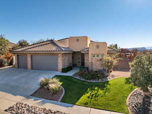 View of front of home featuring stucco siding, stone siding, a garage, concrete driveway, and a tile roof