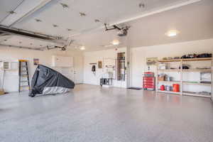 Garage featuring secured water heater and a garage door opener