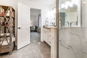 Full bath with vanity, a marble finish shower, and ensuite bathroom