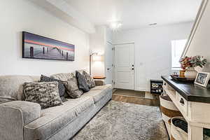 Living area featuring dark wood-style flooring and baseboards