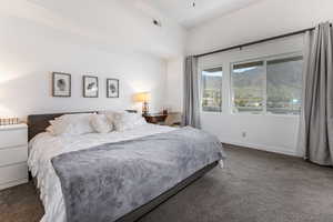 Bedroom with dark carpet and a mountain view