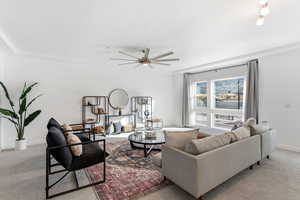 Living room featuring light carpet and a ceiling fan