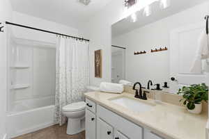 Bathroom featuring vanity, shower / tub combo, and dark tile patterned floors