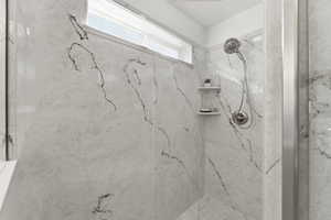 Bathroom featuring a marble finish shower