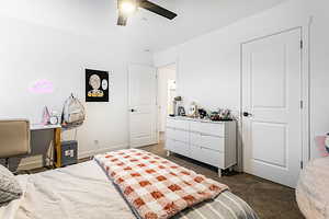 Bedroom with a ceiling fan and dark carpet