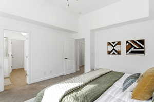Carpeted bedroom featuring baseboards and tile patterned flooring