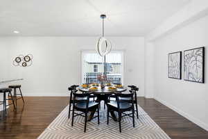 Dining room with dark wood-style flooring and recessed lighting