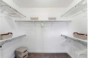 Walk in closet featuring dark carpet