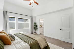 Bedroom with carpet floors, ceiling fan, and connected bathroom