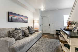 Living room with dark wood-style flooring and baseboards