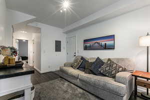 Living area with electric panel and dark wood-style floors