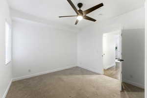 Empty room with light carpet and a ceiling fan
