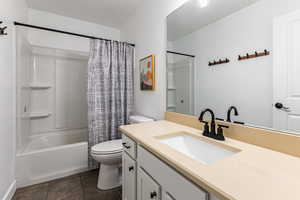 Full bath with shower / bath combo with shower curtain and vanity