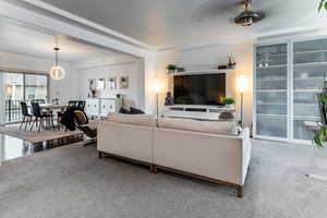 Carpeted living room with a textured ceiling