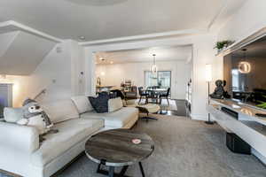 Living area featuring carpet flooring and a chandelier