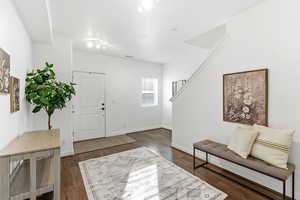 Foyer with dark wood-style flooring and baseboards