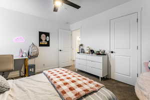 Bedroom featuring ceiling fan and dark colored carpet