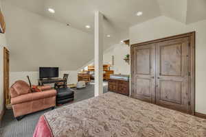 Carpeted bedroom featuring lofted ceiling, recessed lighting, and an office area