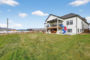Back of property featuring stairway, a patio area, a lawn, and a playground