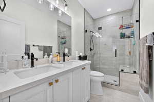 Bathroom with double vanity, a stall shower, and light tile patterned floors