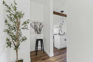 Hallway with dark wood-style floors and a sink