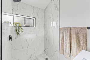 Bathroom featuring a marble finish shower