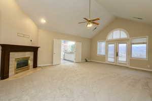 Spacious and light primary bedroom suite with high vaulted ceiling,  fireplace, french doors leading to a private deck.