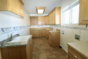 Laundry room for two laundry sets, gas connections,  a sink, tile  flooring, and ample cabinet space